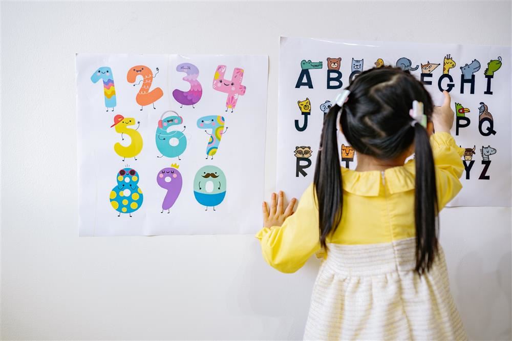  girl at board playing with letters and numbers 